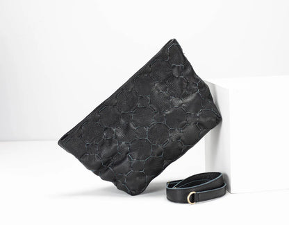 Black textured clutch bag with a matching belt on a white background