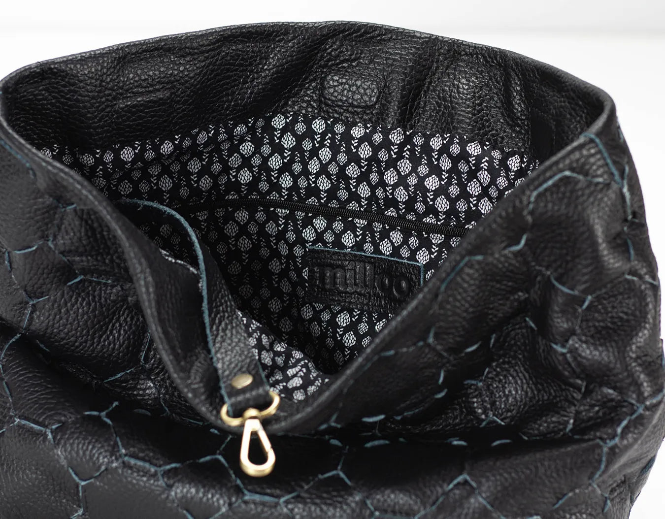 Close-up of a black textured handbag with visible brand name.