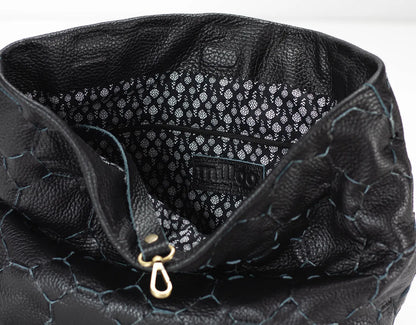 Close-up of a black textured handbag with visible brand name.