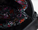 Floral-patterned bag strap with a dark background