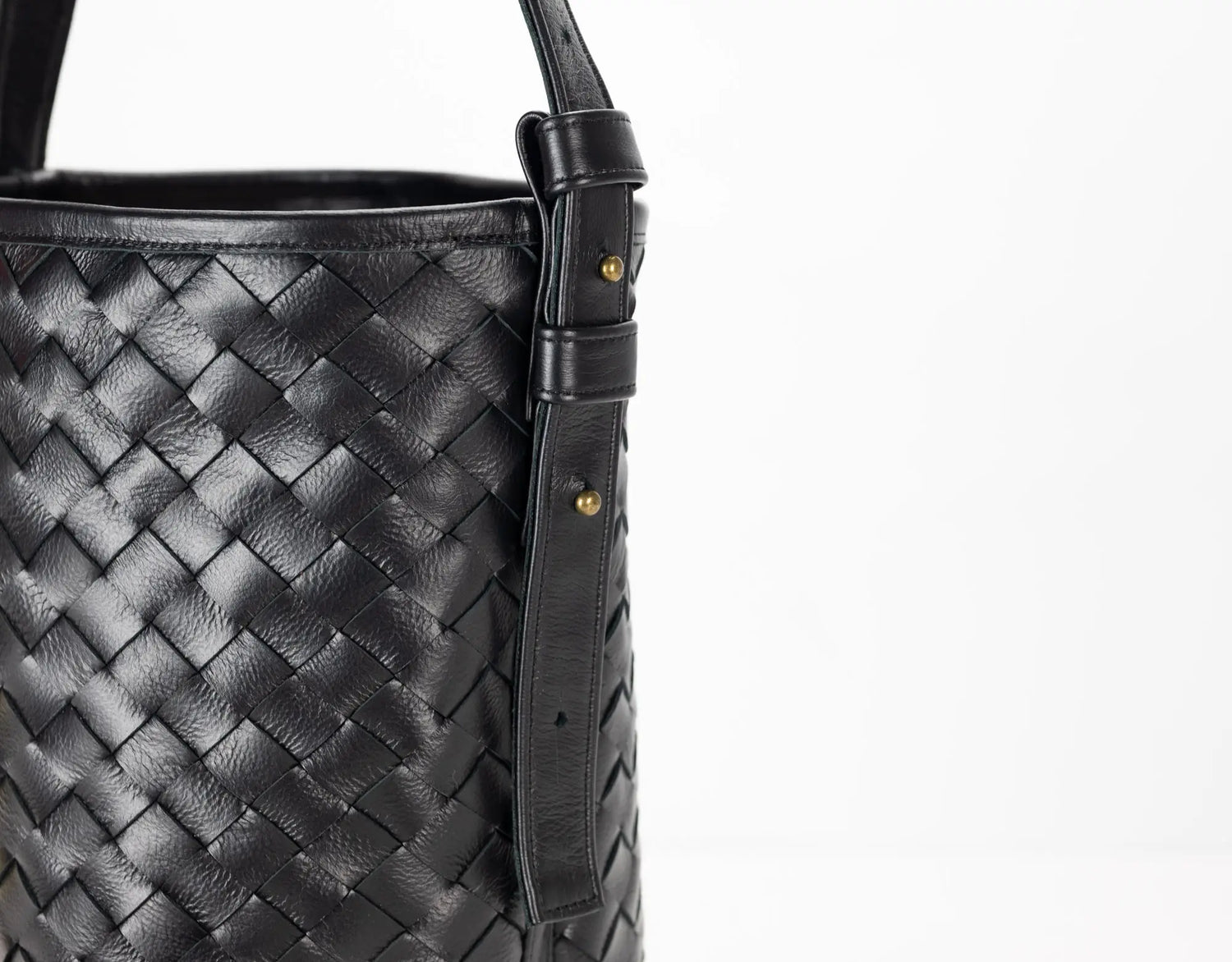 Black woven leather handbag with a strap on a white background