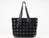 A black woven leather tote bag with long shoulder straps, photographed against a plain white background.