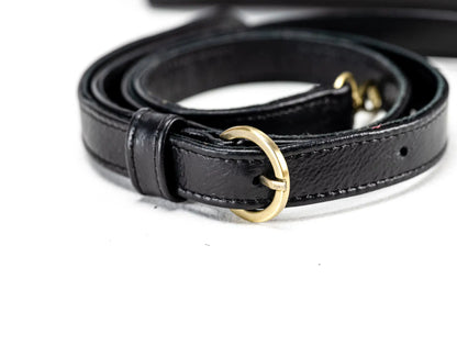 Black leather belt with a gold buckle on a white background