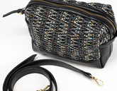 Black and gold patterned handbag with a strap on a white background