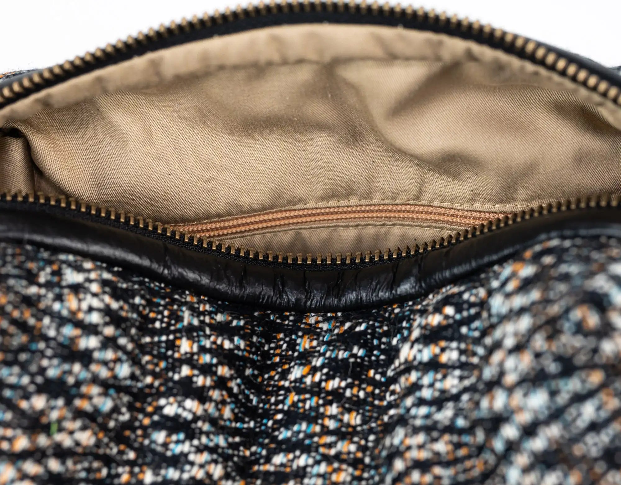Close-up of a textured fabric interior of a bag with a zipper.