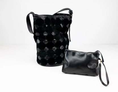 Two black leather bags, one with a textured pattern and the other a plain pouch, on a white background.