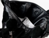 Close-up of a black leather jacket with a brand label inside
