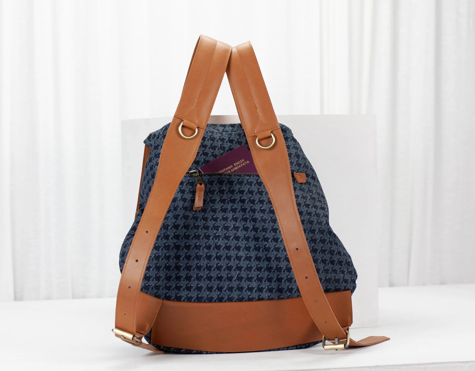 Blue patterned backpack with brown straps on a white background