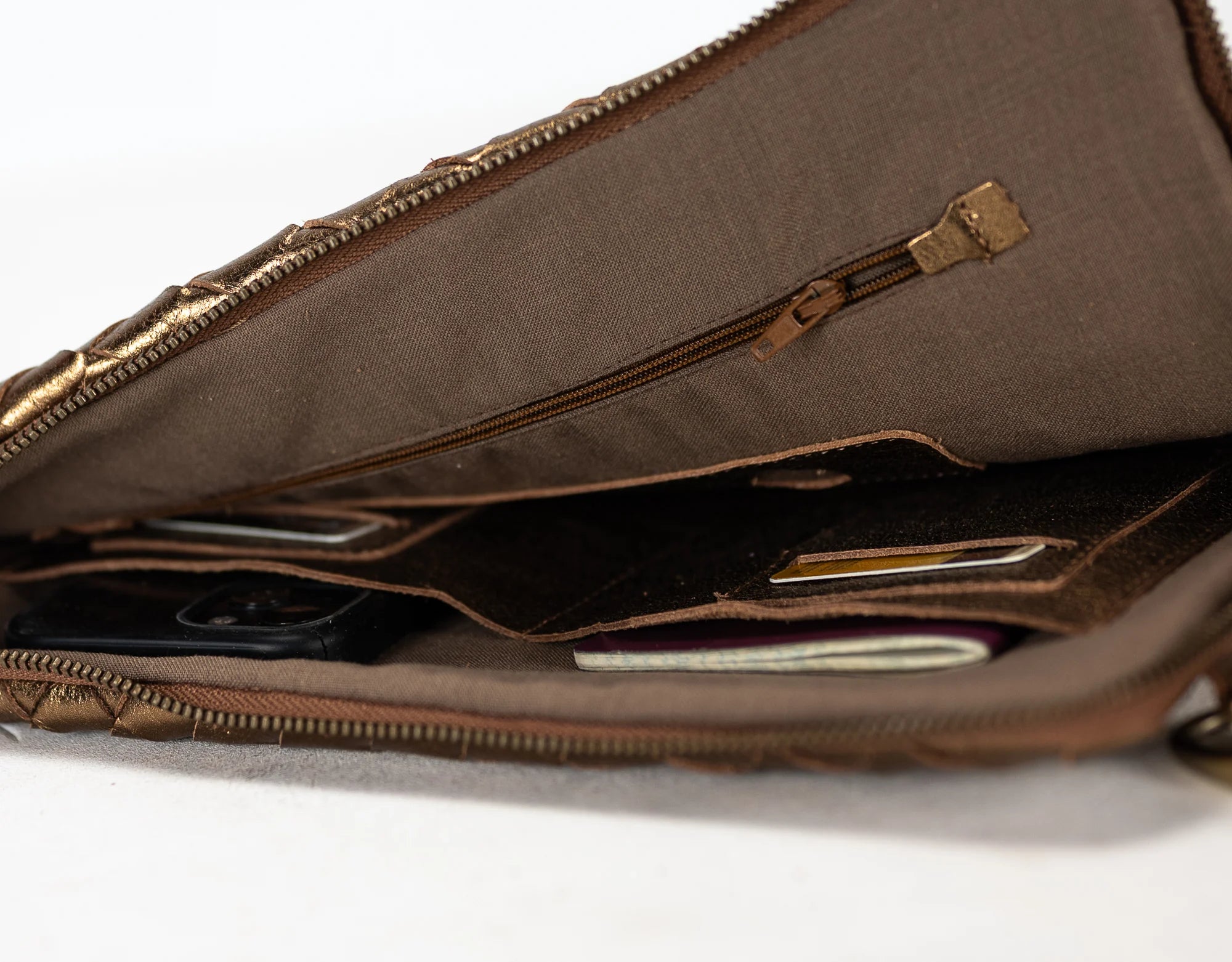 Brown leather bag with a zipper on a white background