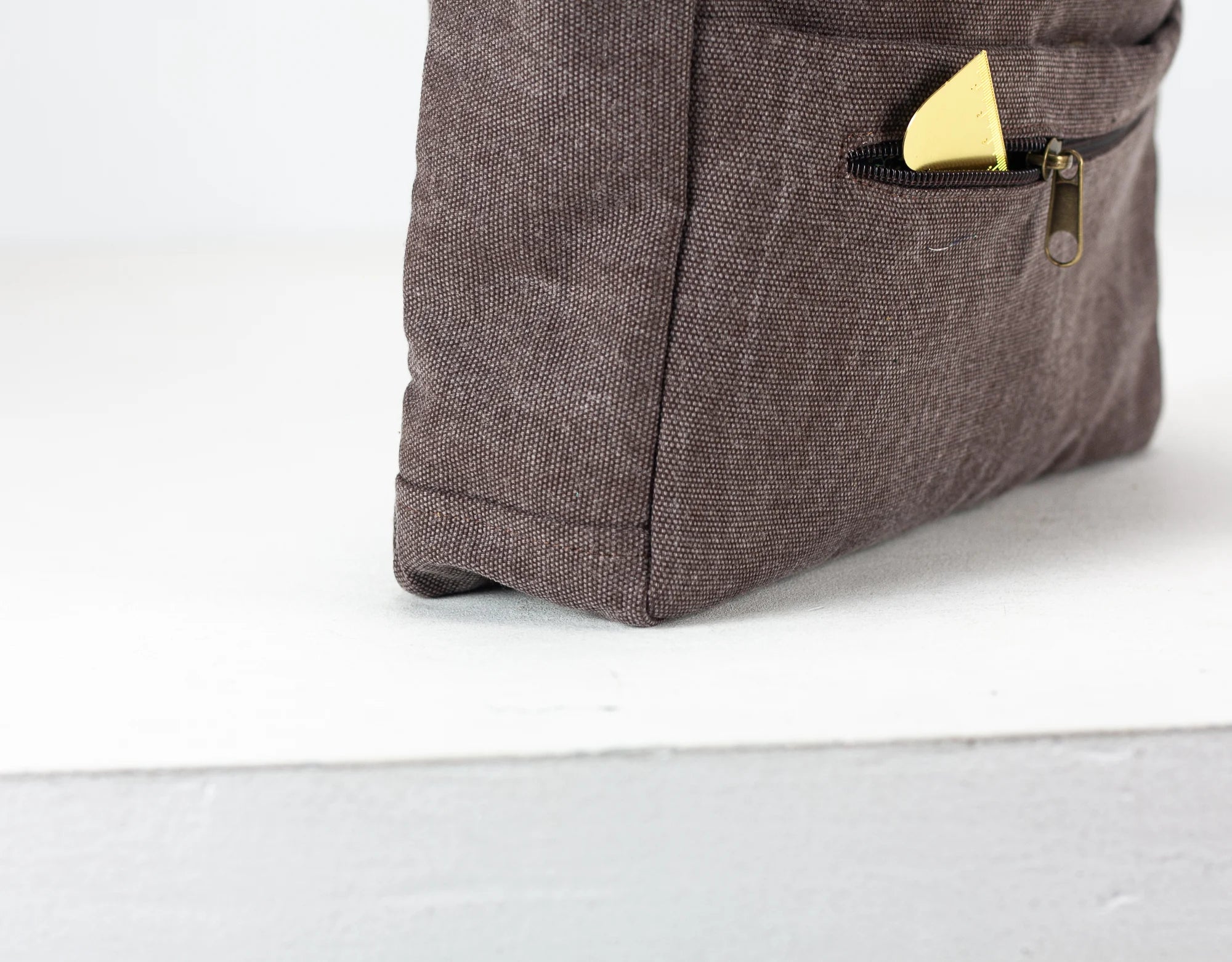 Brown textured purs insert with a gold pen in a pocket on a white background