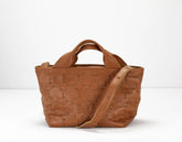 Brown textured handbag with a shoulder strap on a white background