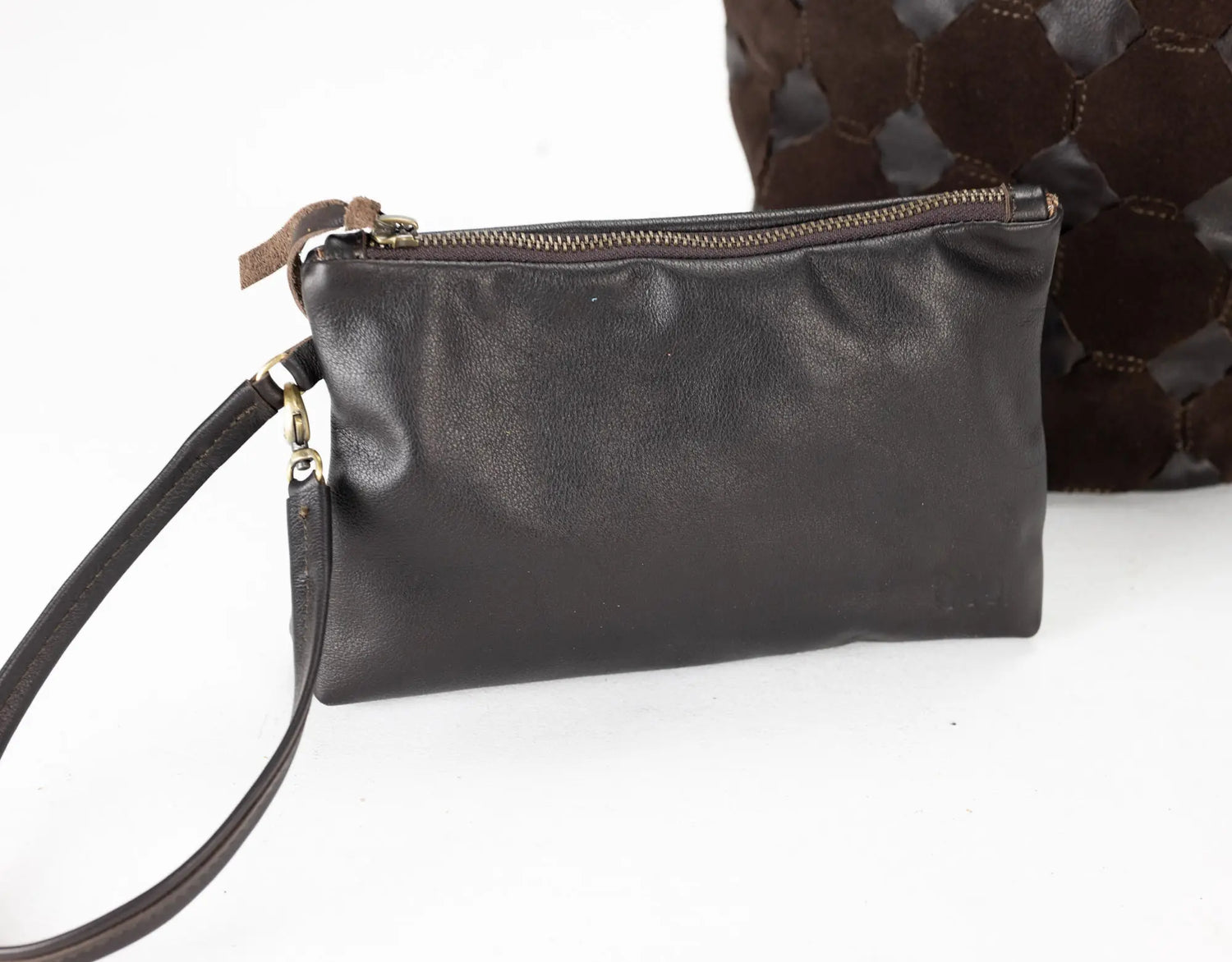 Black leather clutch bag with a strap on a white background