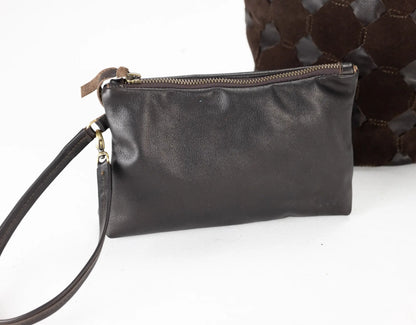 Black leather clutch bag with a strap on a white background