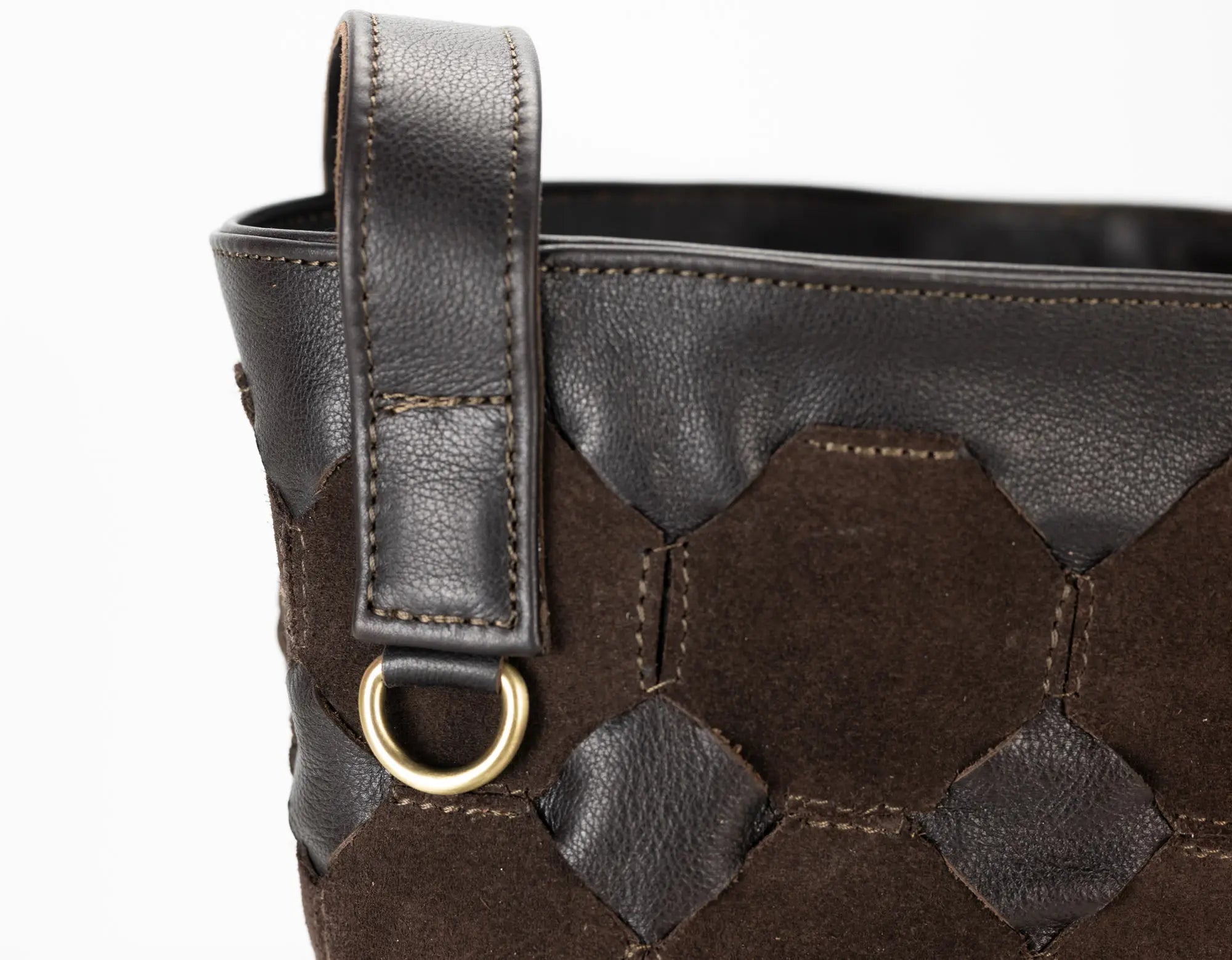 Brown leather handbag with geometric pattern and gold ring detail on a white background