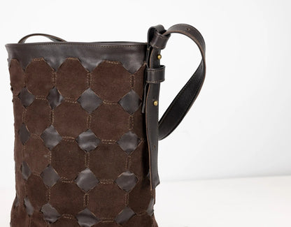 Brown leather bag with geometric pattern on a white background