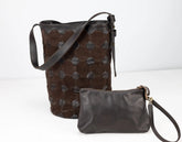 Brown leather bucket bag and matching wristlet on a white background