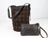 Brown leather bucket bag and matching wristlet on a white background