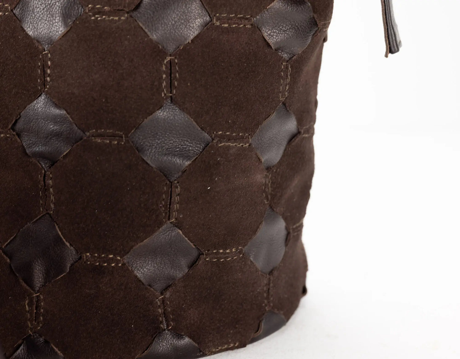 Close-up of a brown woven leather handbag on a white background