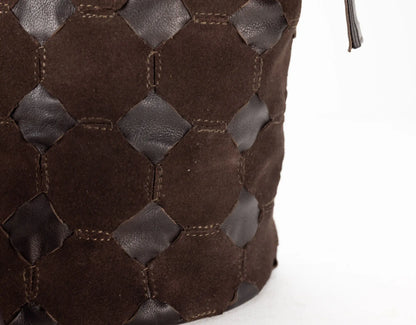 Close-up of a brown woven leather handbag on a white background