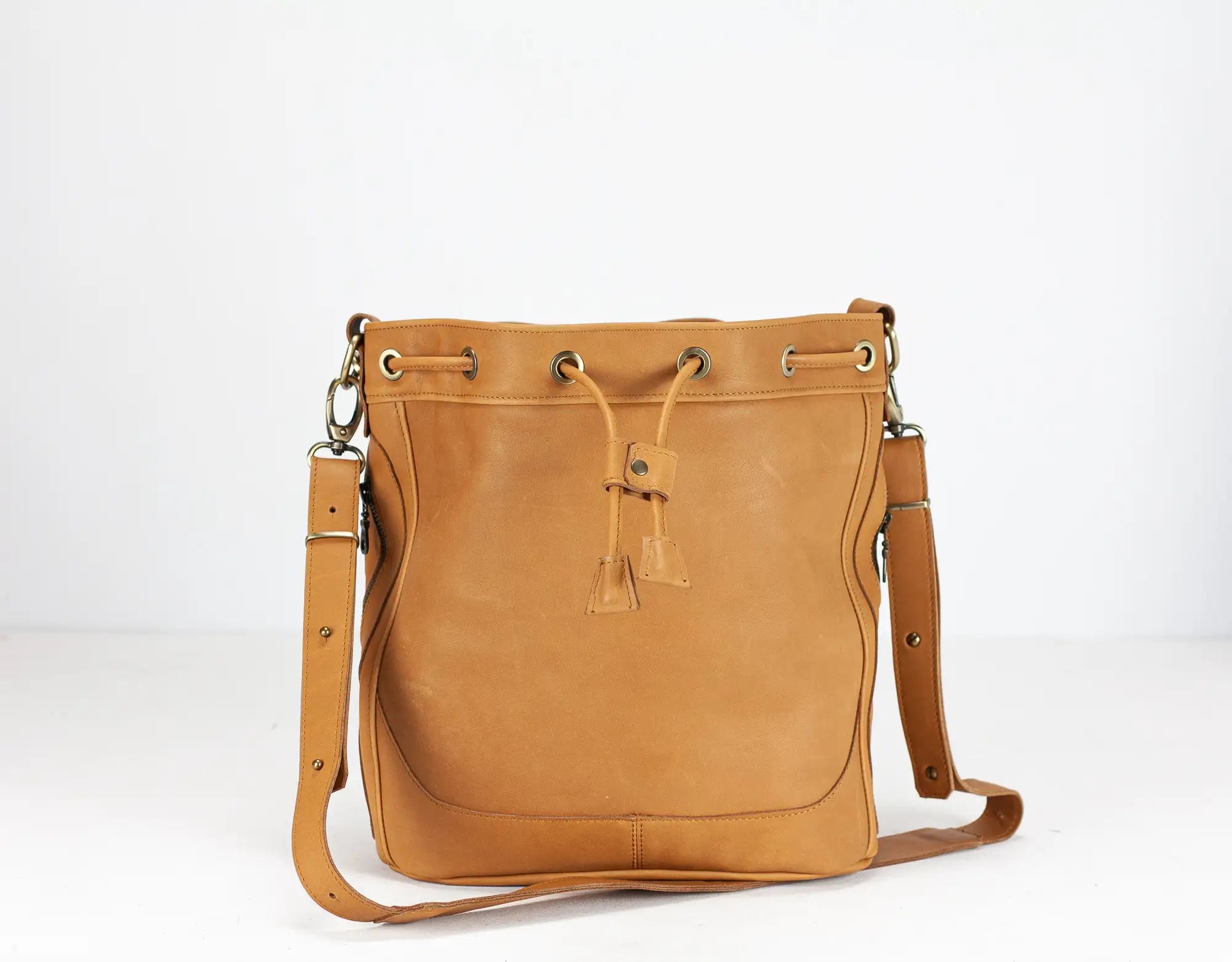 Brown leather handbag with drawstring on a white background