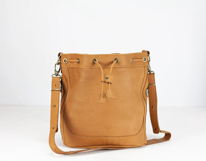Brown leather handbag with drawstring on a white background