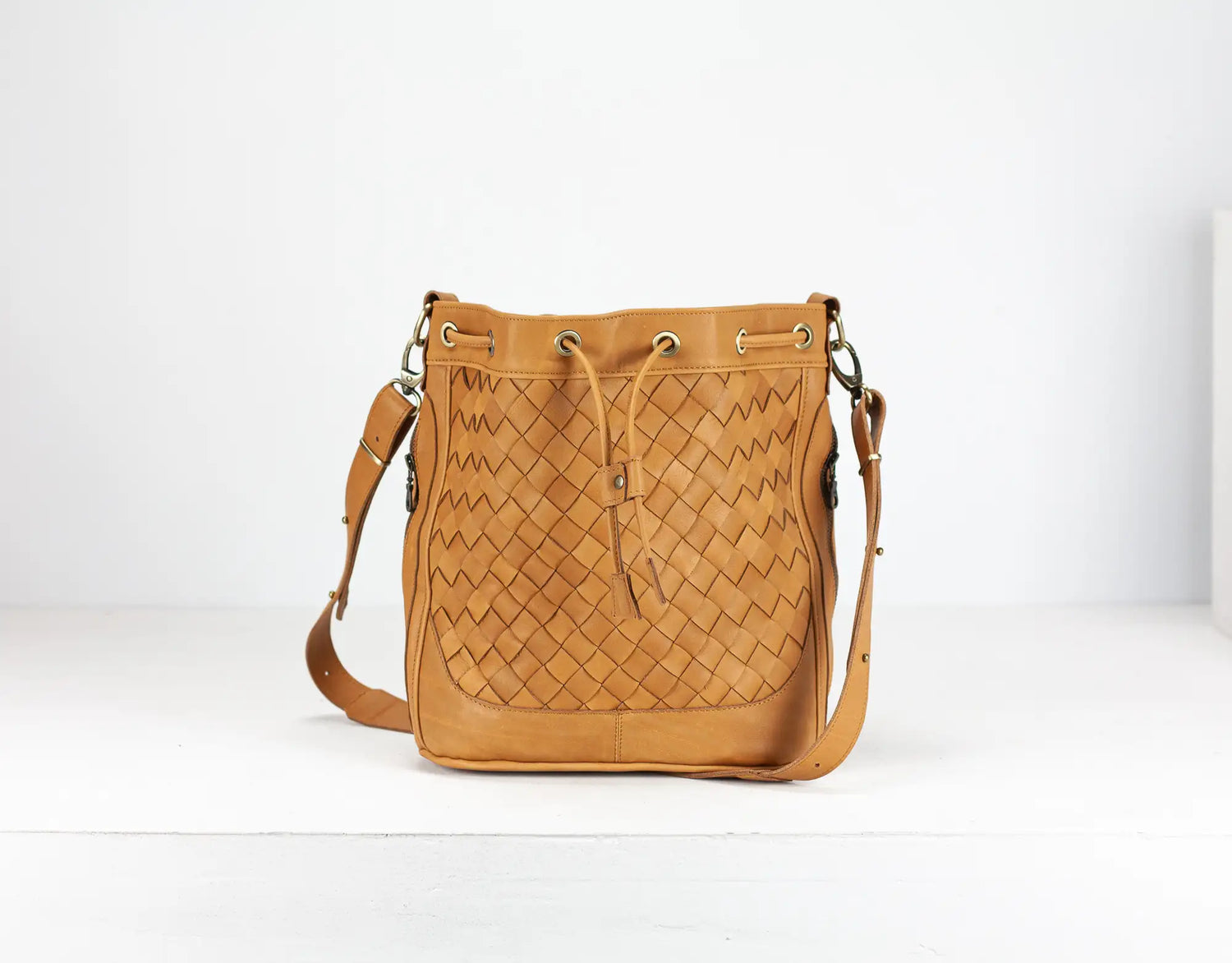 Tan woven leather bag on a white background
