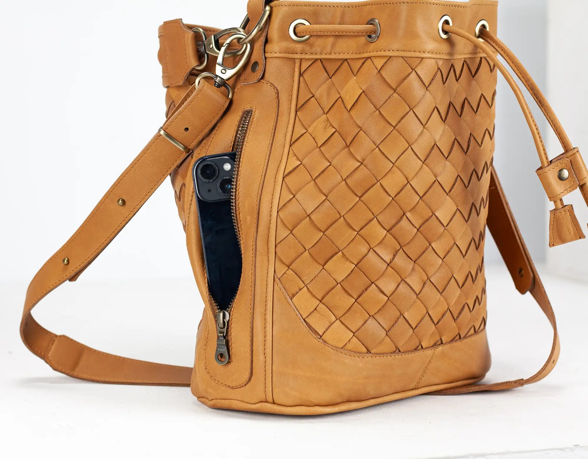 Brown woven bucket bag with a visible brand logo on a white background