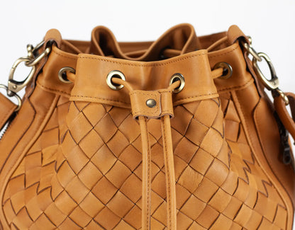 Brown woven handbag with drawstring on a white background