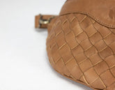 Close-up of a brown woven leather bag on a white background