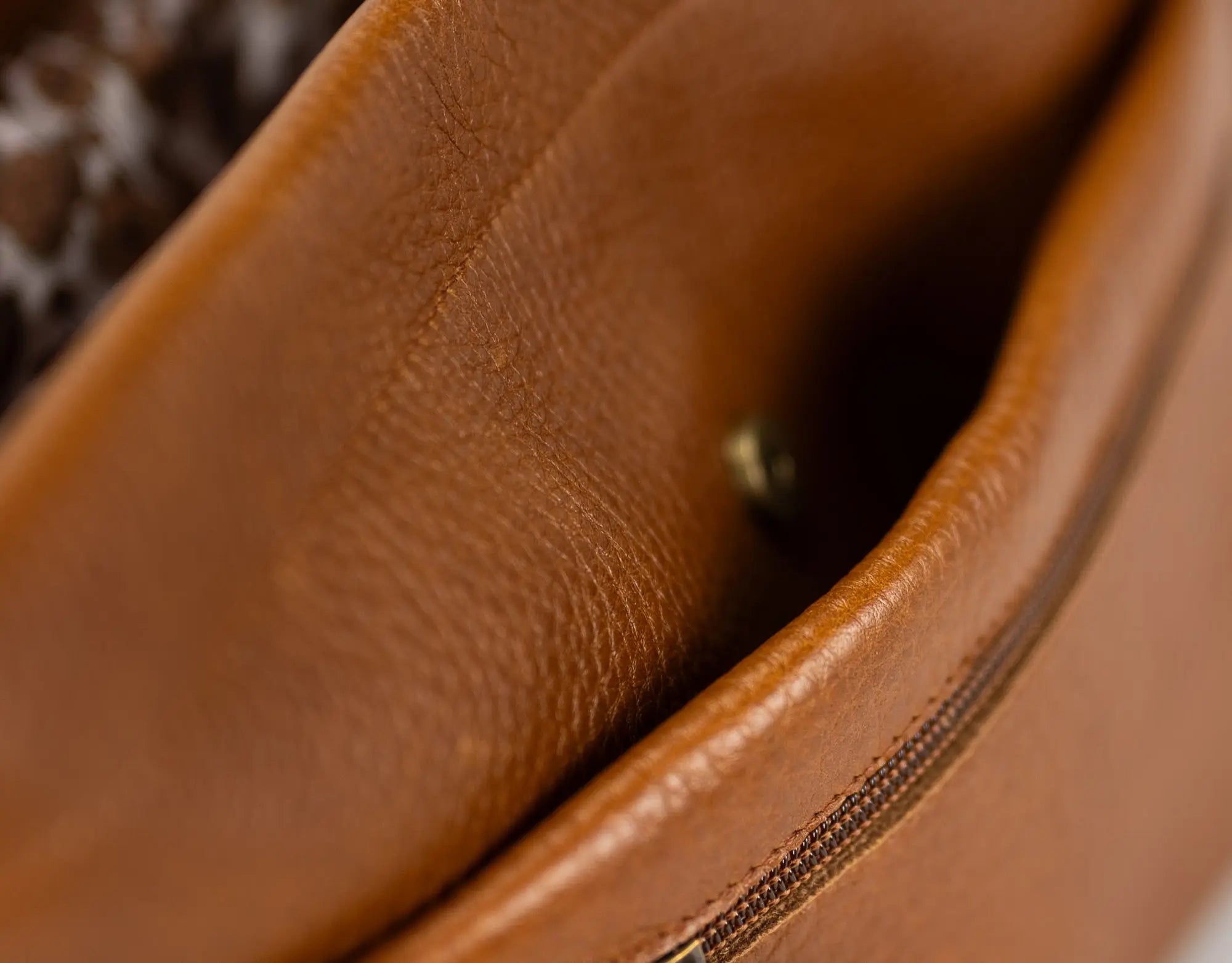 Close-up of a brown leather bag with visible stitching