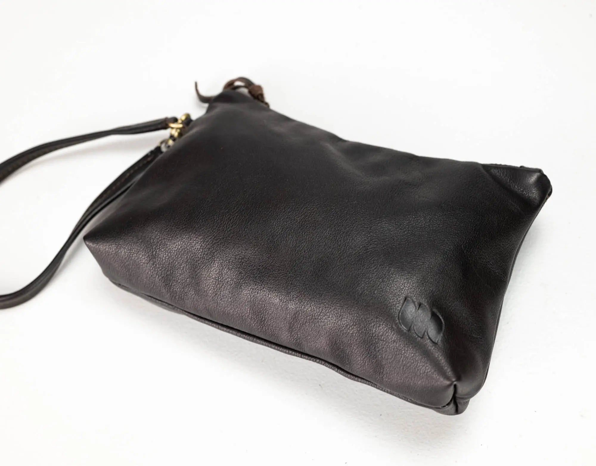 A black leather clutch bag with a matching wrist strap and small gold hardware, photographed on a plain white background.