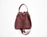 Burgundy leather bucket bag on a white background