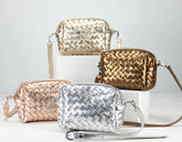 Four woven handbags in gold, silver, and rose gold on a light gray background
