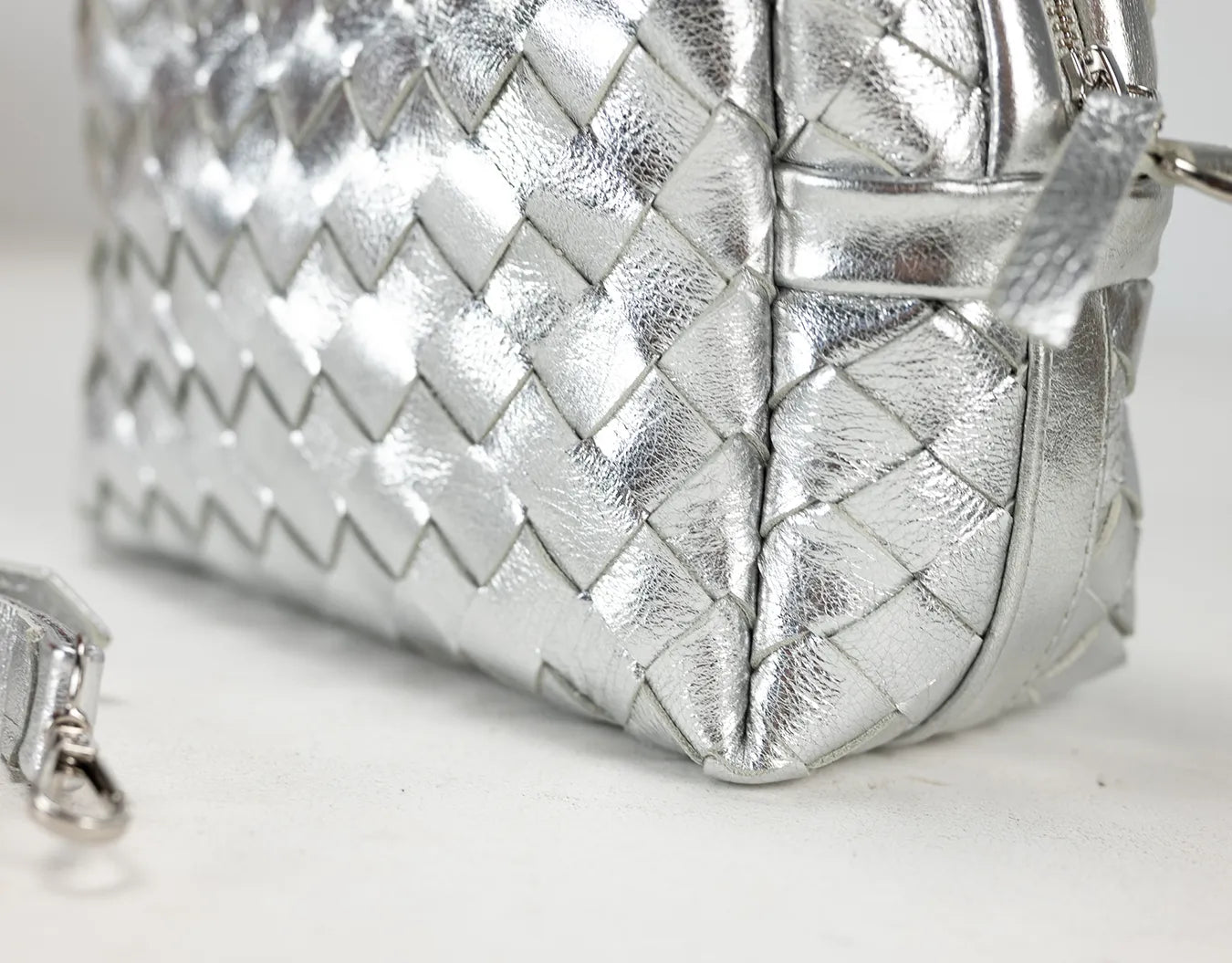 Silver woven handbag on a light background
