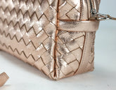 Rose gold handbag with a textured pattern on a light background