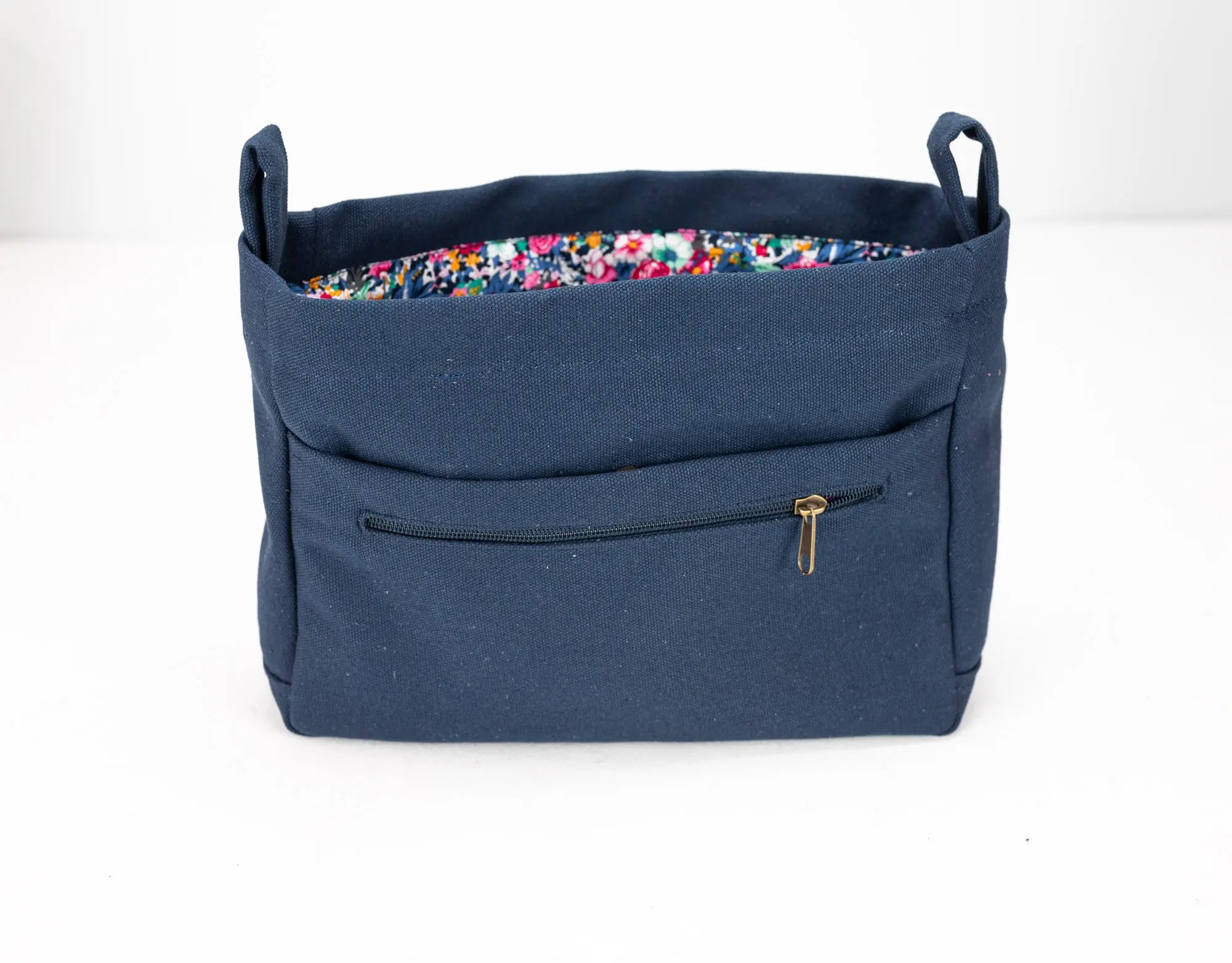Blue bag with floral lining on a white background