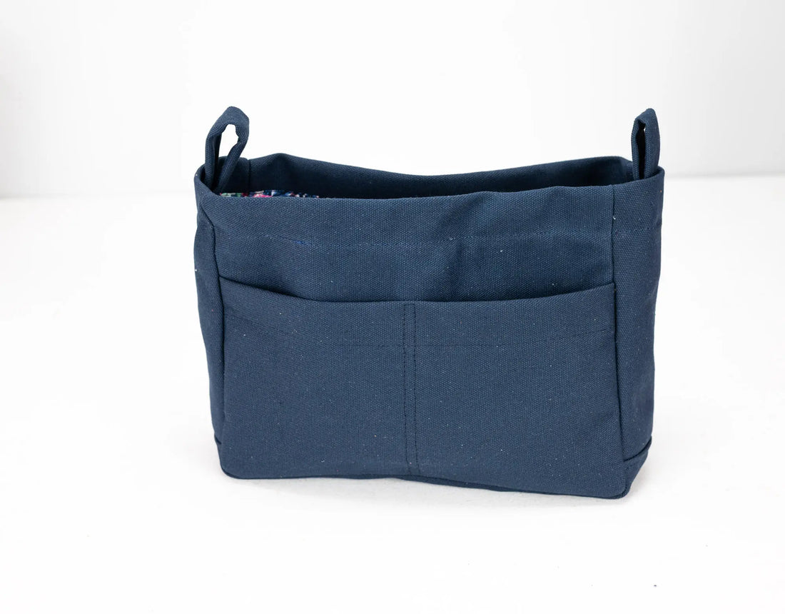 Blue fabric basket with handles on a white background