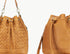 Brown leather bucket bag with woven pattern on a white background