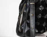 Black leather bag with floral pattern on a white background