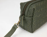 Green woven handbag with a gold zipper on a white background