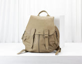 Beige backpack on a white surface with a light background