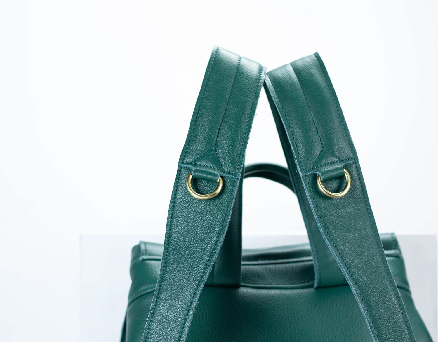 Green handbag with gold hardware on a white background