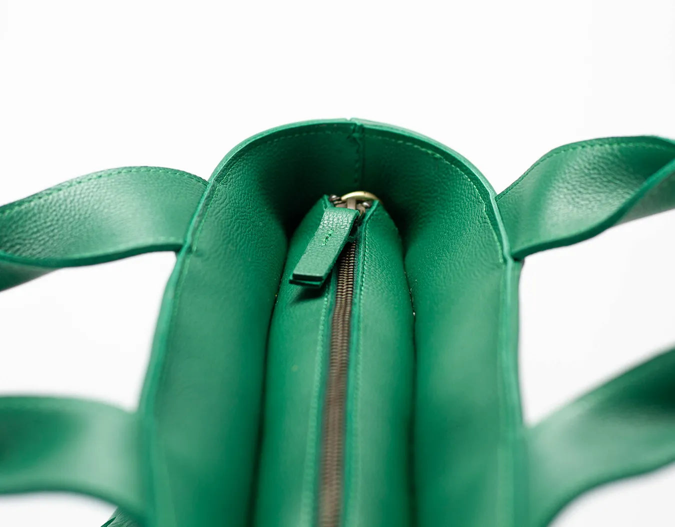 Green leather bag with a zipper on a white background