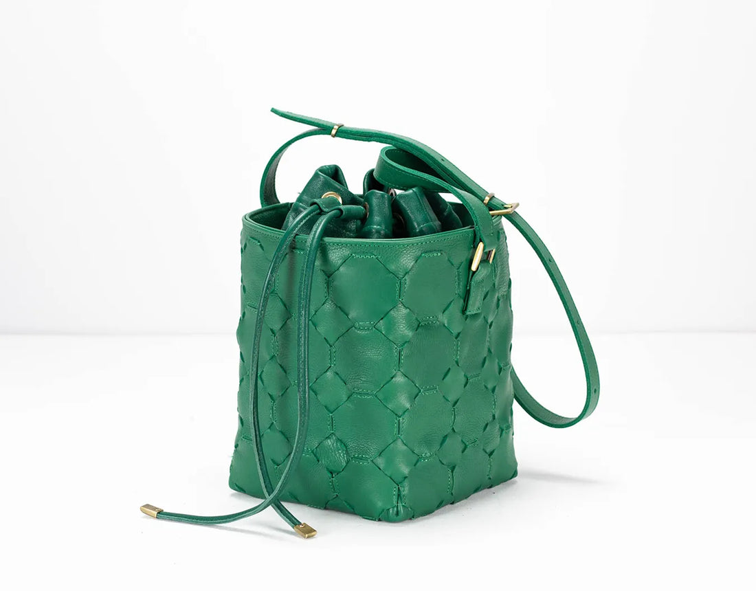 Green quilted handbag on a white background