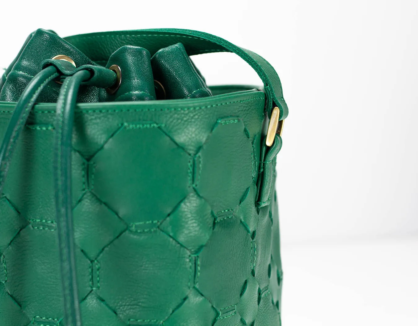Green woven leather bucket bag on a white background