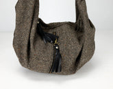 Brown textured handbag with a black zipper on a white background