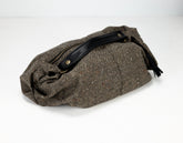 Brown woven bag with a black strap on a white background