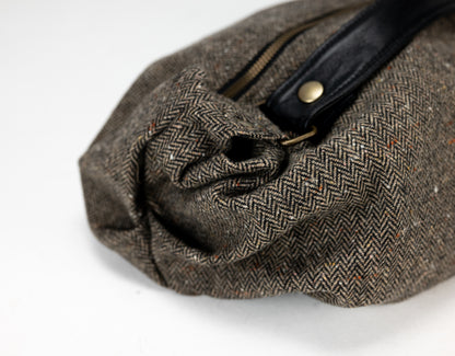 Brown tweed bag with a black strap on a white background