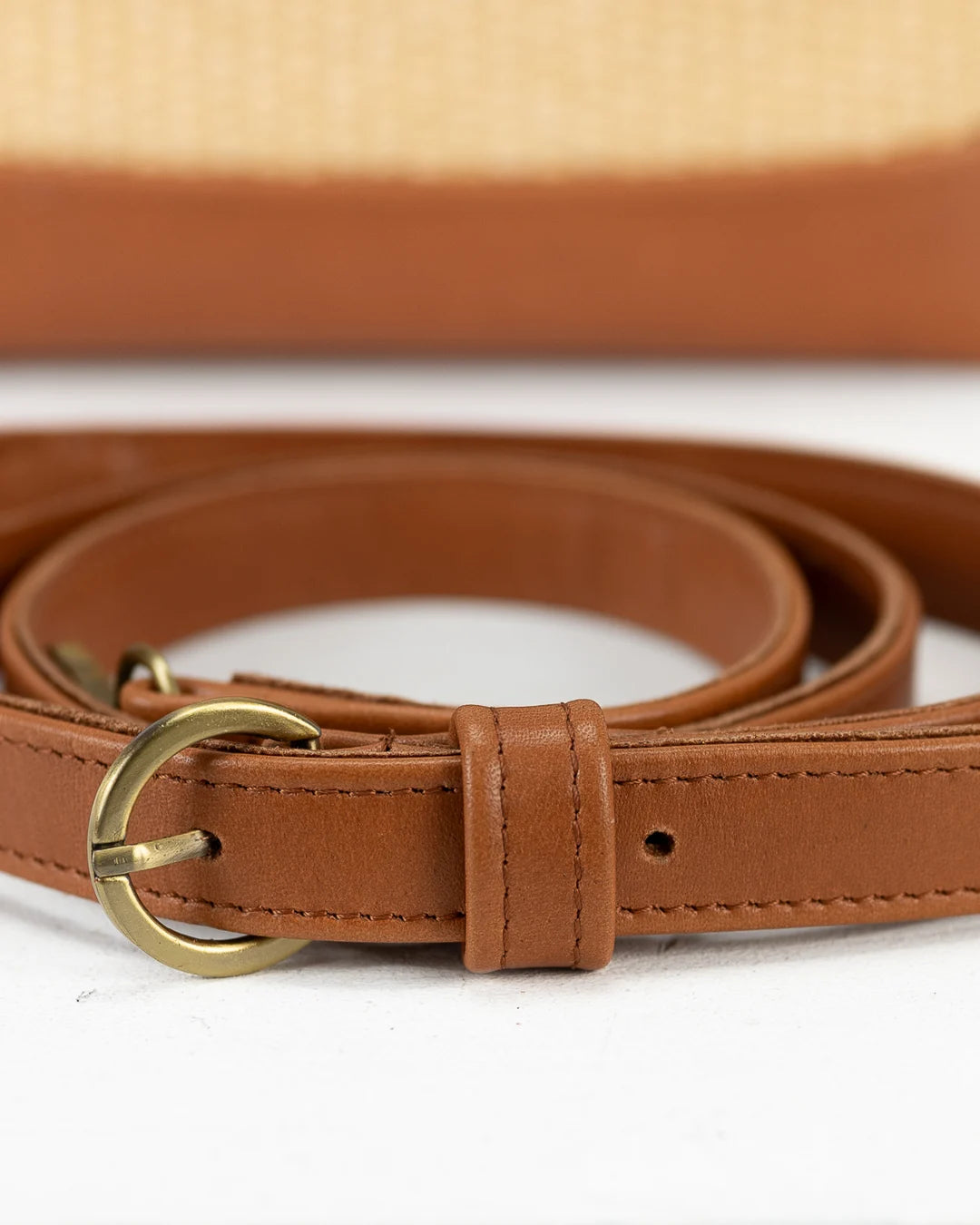 Brown leather belt with a gold buckle on a white background