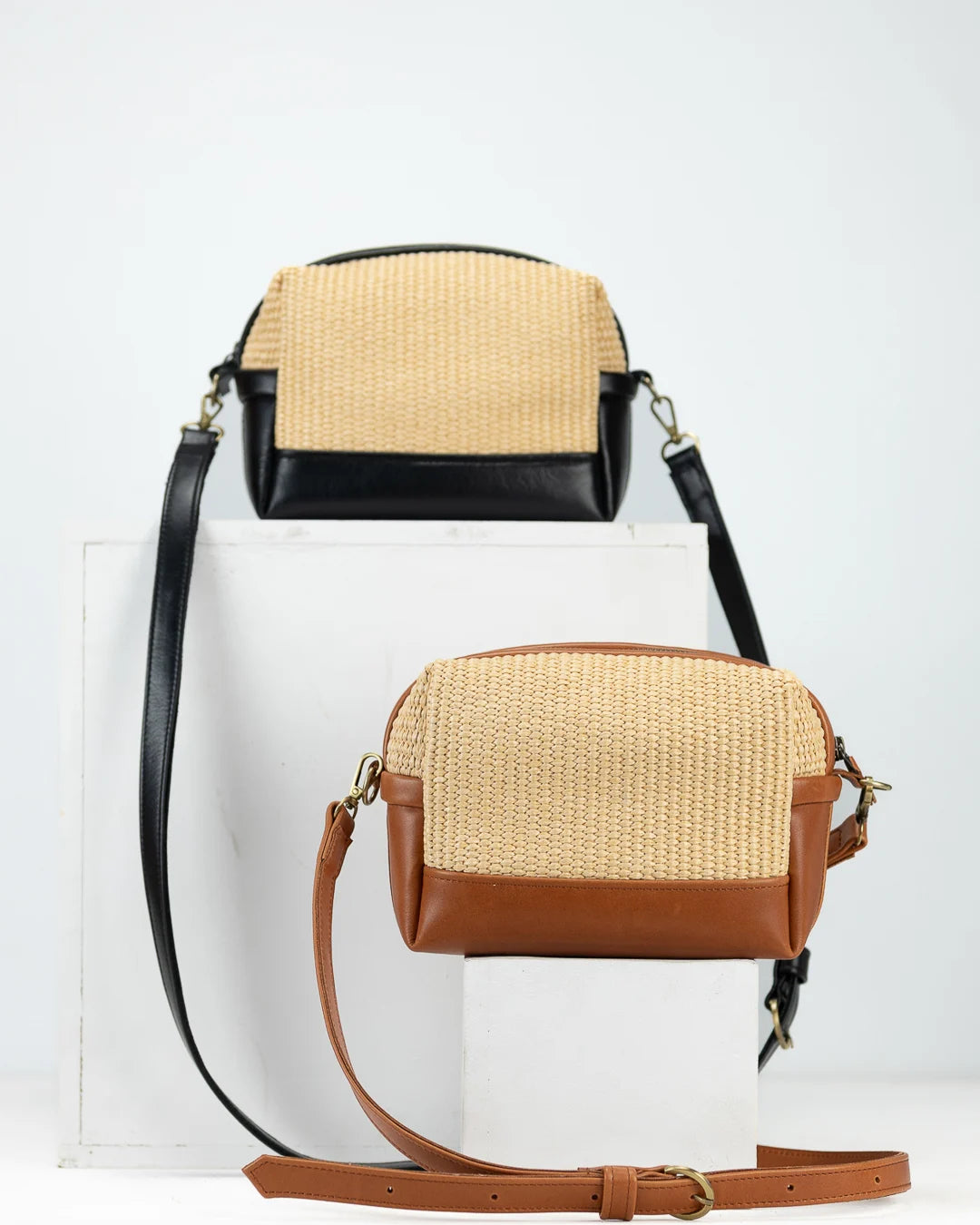 Two-tone handbag with straw and leather design on a white background